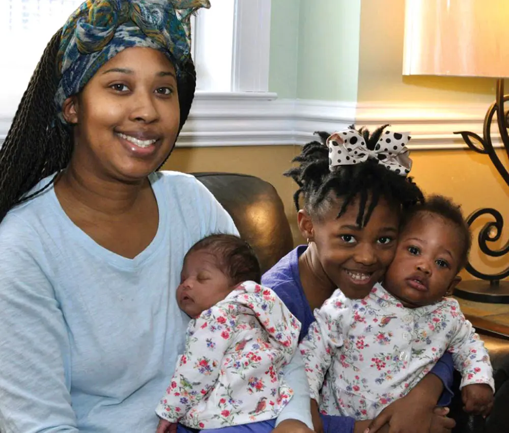 A mother sits with her 3 children