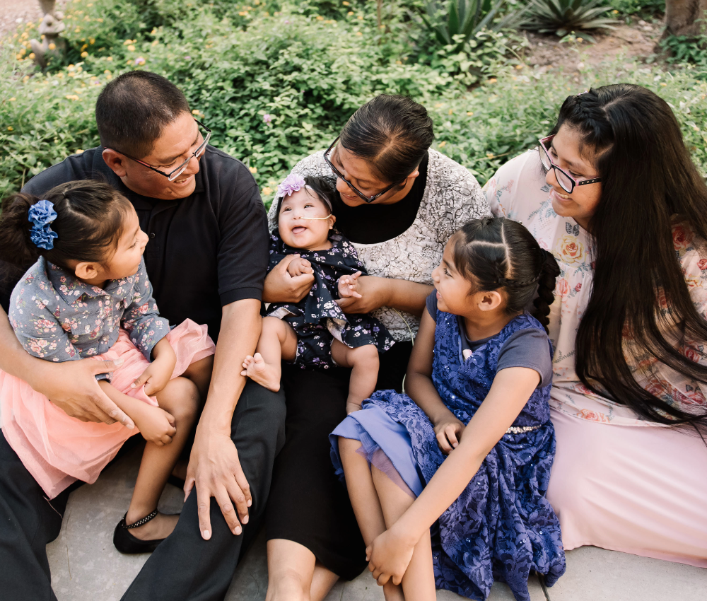 Family sitting on ground with 3 kids