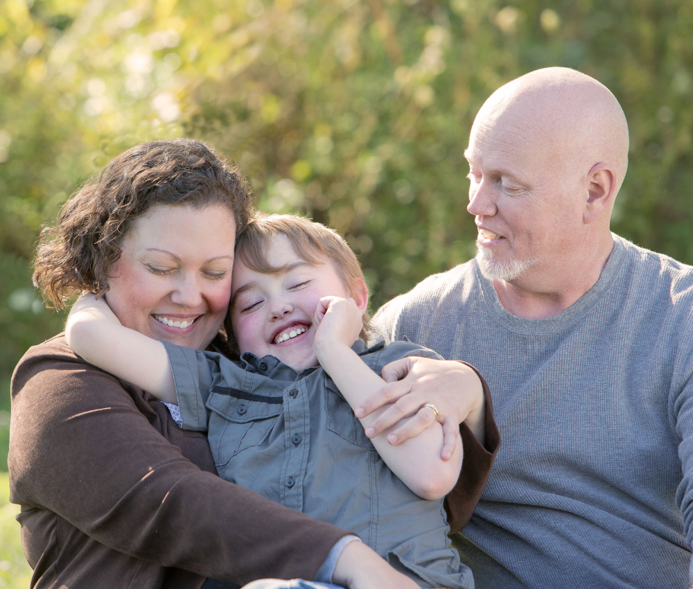 Dad and son hugging Mom