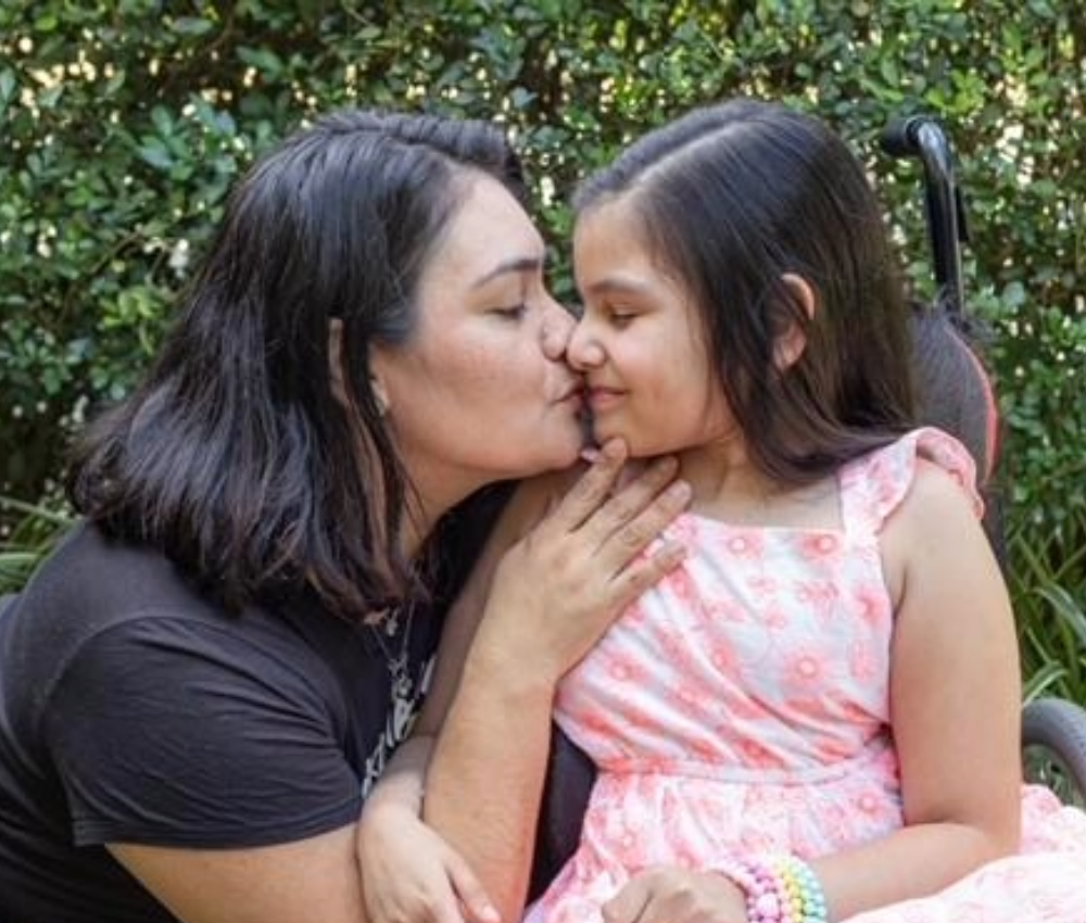 Mom kissing daughter